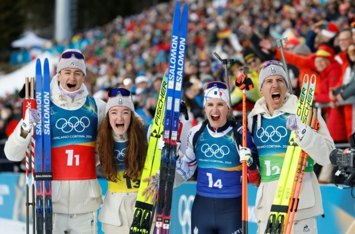 (De gauche à droite): Éric Perrot, Lou Jeanmonnot, Julia Simon et Quentin Fillon Maillet après leur titre sur le relais mixte des JO-2026, à Anterselva, en Italie, le 8 février 2027