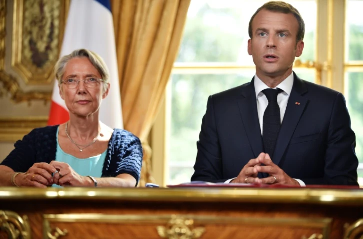 Le président français Emmanuel Macron, accompagné de la ministre des Transports Elisabeth Borne, lors de la promulgation de la réforme de la SNCF, le 27 juin 2018 à Paris