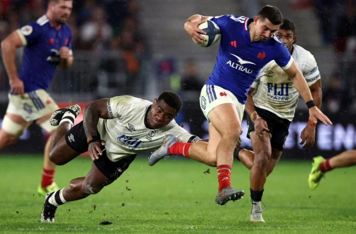 L'arriÚre du XV de France Thomas Ramos (D) échappe au plaquage du Fidjien Josua Tuisova lors du match international remporté par les Bleus (34-21), le 15 novembre 2025 à Bordeaux