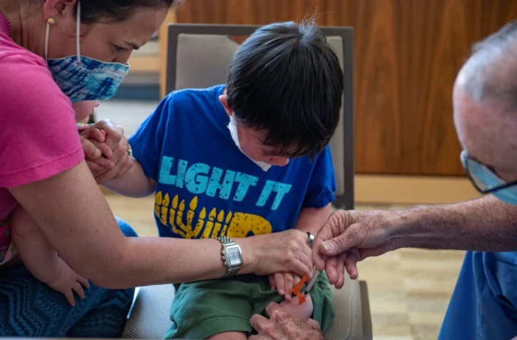 Un enfant de trois ans reçoit une dose de vaccin anti-Covid au Temple Beth Shalom à Needham, dans l'Etat du Massachusetts, le 21 juin 2022