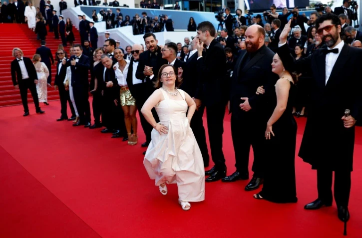 L'équipe d'"Un p'tit truc en plus", dont la comédienne Marie Colin (C) et le réalisateur Artus (derrière, au centre) au 77e festival de Cannes le 22 mai 2024