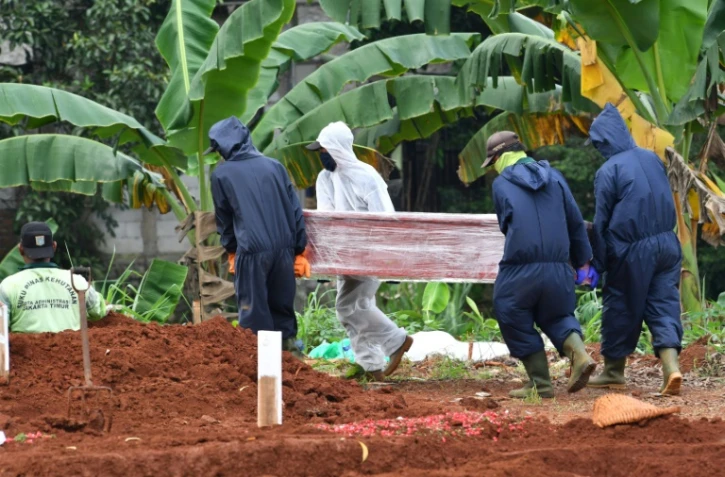 Des fossoyeurs portent le cercueil d'une personne décédée du coronavirus au cimetière de Pondok Ranggon, le 6 mai 2020 à Jakarta, en Indonésie