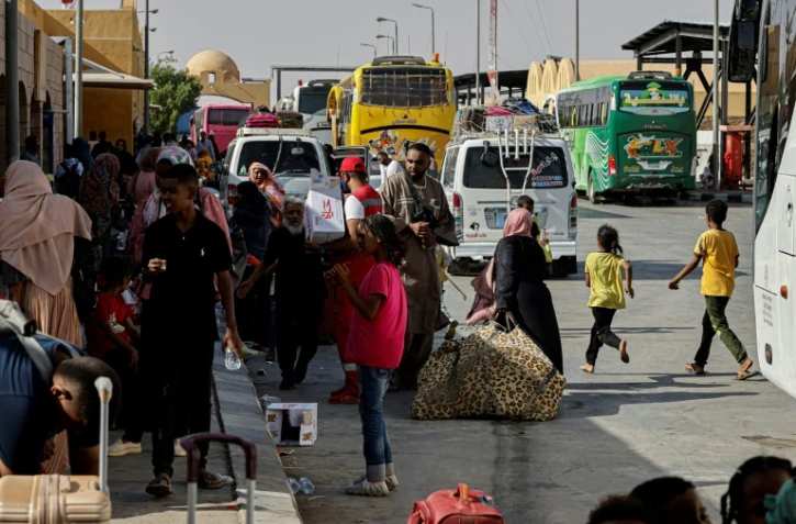Des personnes fuyant le Soudan déchiré par la guerre arrivent au port terrestre de Qastal, point de passage entre l'Egypte et le Soudan, le 13 mai 2023