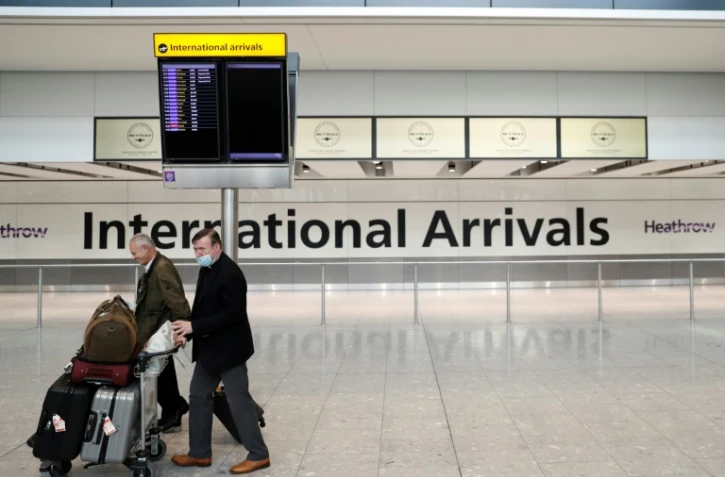 Le prêtre Alistair Macdonald (R) arrive à l'aéroport de Heathrow, le 8 juin 2020