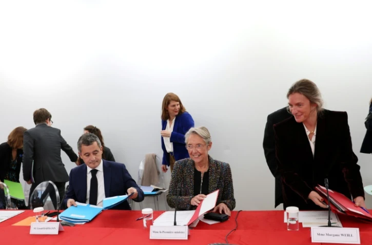 La Première ministre Elisabeth Borne (C) et le ministre de l'Intérieur Gérald Darmanin participent au 3e Comité interministériel à l'enfance, le 20 novembre 2023 à Paris