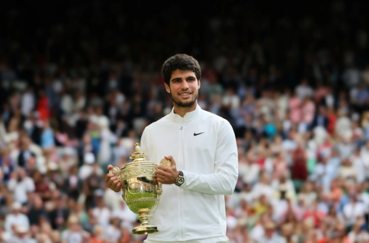 L'Espagnol Carlos Alcaraz brandit le trophée du vainqueur de Wimbledon, après avoir battu le Serbe Novak Djokovic en finale du simple messieurs, le 16 juillet 2023, à Londres.
