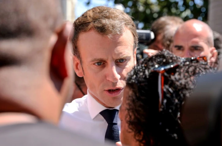Le président Emmanuel Macron parle avec des habitants du quartier rénové des Camélias, le 24 octobre 2019 à Saint-Denis-de-la-Réunion