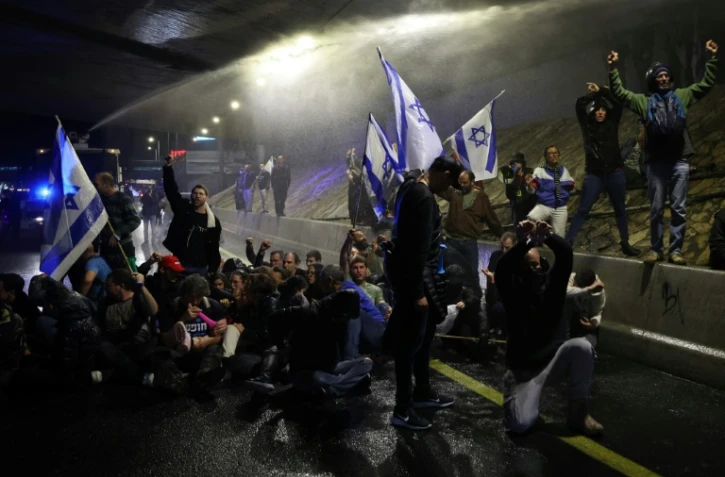 Les forces de sécurité israéliennes utilisent un canon à eau pour disperser des manifestants rassemblés à Tel-Aviv pour exiger le départ du gouvernement de Benjamin Netanyahu et le retour des otages isaréliens détenus par le Hamas, le 9 mars 2024