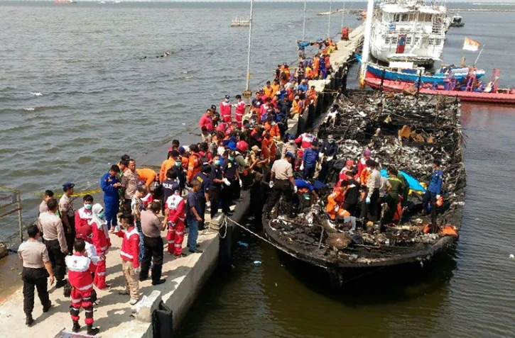 Des sauveteurs indonésiens près du bateau qui transportait environ 200 personnes au large de la côte de Jakarta à l'île de Tidung et qui a pris feu faisant 23 morts et 17 disparus, le 1er janvier 2017