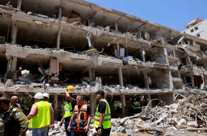 Des secouristes israéliens devant un bâtiment détruit après une frappe iranienne, le 22 juin 2025 à Tel-Aviv 