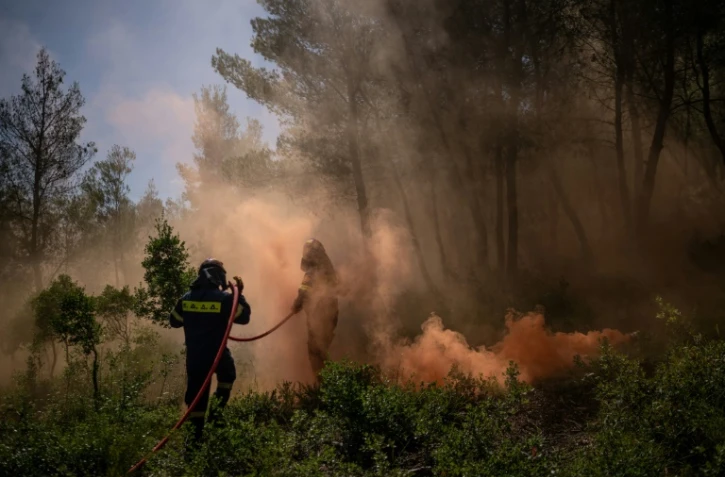 Des pompiers volontaires participent à un exercice de simulation d'incendie, à Rodopoli, dans la banlieue d'Athènes, le 18 mai 2025 en Grèce