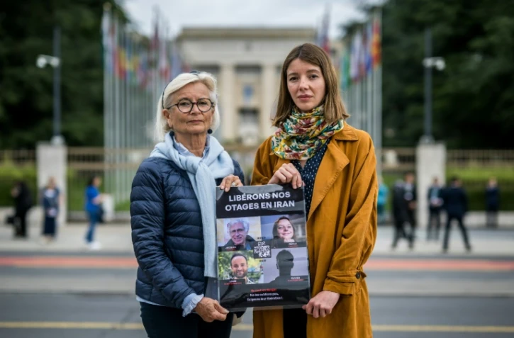 Sylvie Arnaud, mère de Louis Arnaud (g) et Noemie Kohler, sœur de Cécile Kohler (d), deux parents de Français détenus en Iran, posent devant les bureaux des Nations Unies à Genève, le 27 mai 2024