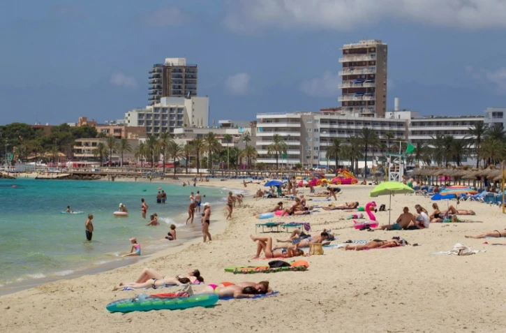 Des touristes prennent le soleil sur la plage de Magaluf à Calvia, sur l'île de Majorque, dans les Baléares, le 28 juin 2021
