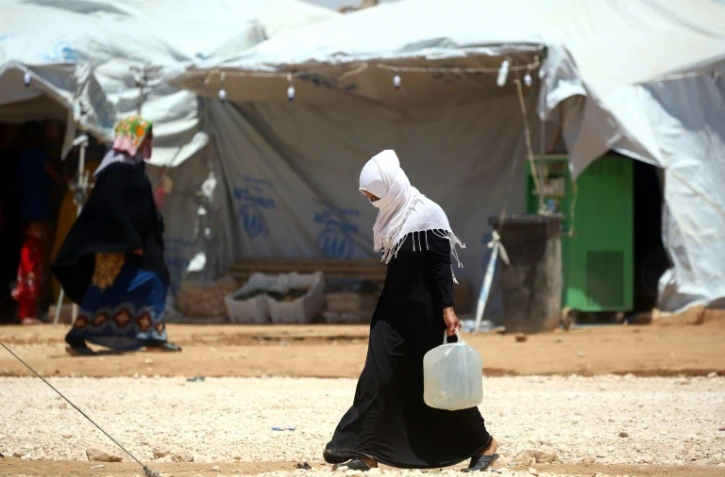 Une Syrienne qui a fui les combats à Raqa porte un bidon d'eau, le 9 juin 2017 à Ras al-Ain