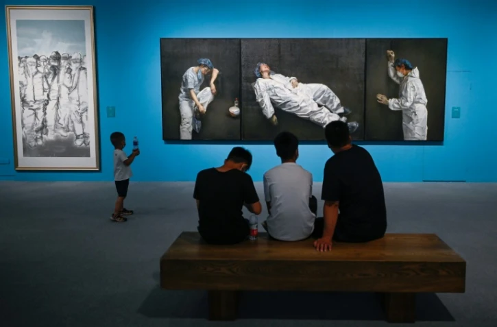 Des visiteurs parcourent l'exposition ?L'union fait la force" sur le combat contre le Covid-19 qui présente notamment un tableau de l'artiste Pang Maokun, au musée national de Chine à Pékin le 5 août 2020