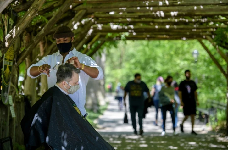 Le coiffeur de Central Park, Herman James, coupe les cheveux d'un client Ă Central Park, Ă New York, le 6 mai 2021