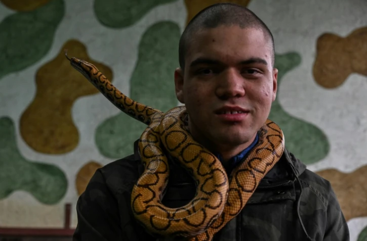 David de Oliveira Gomes assiste à une séance de thérapie avec des reptiles à la Walking Equotherapy Clinic de Sao Paulo, au Brésil, le 30 mai 2023