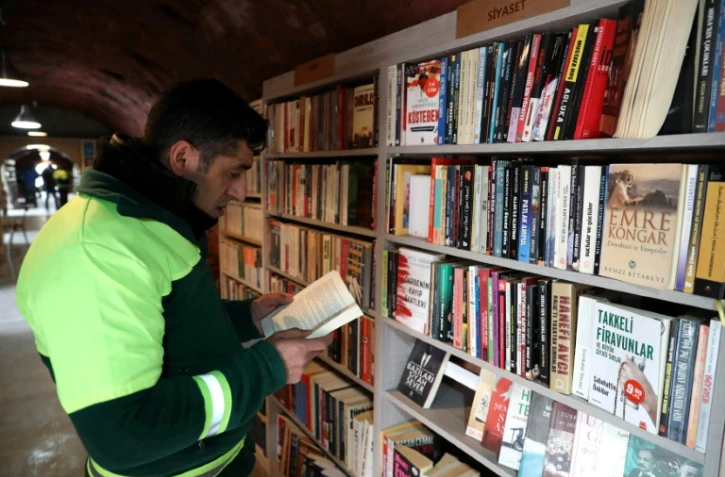 Un homme lit un livre dans une bibliothèque créée par des éboueurs d'Ankara, le 9 janvier 2018