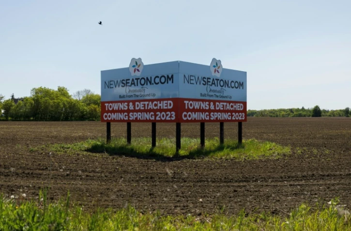 Un panneau publicitaire dans un champ de la réserve agricole de Duffins-Rouge annonçant de nouvelles constructions, dans la ceinture verte de Toronto, le 25 mai 2023 au Canada