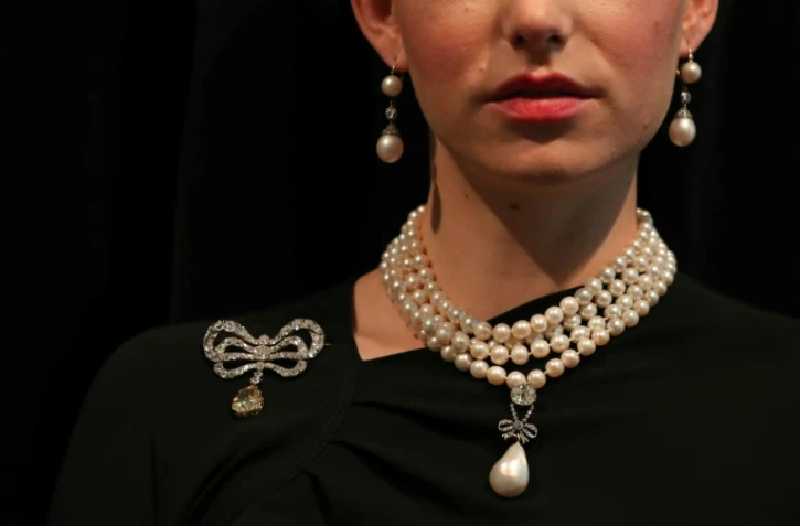 Un modèle porte un collier de perles et une broche ayant appartenu à la reine Marie-Antoinette de France, chez Sotheby's à Londres le 19 octobre 2018