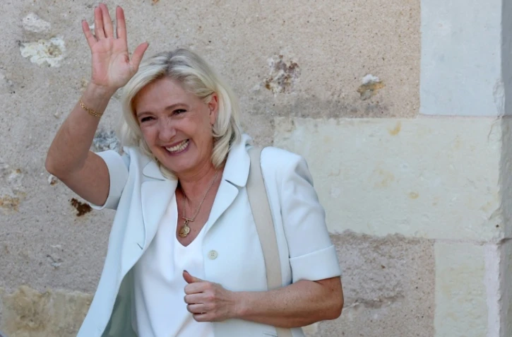 Marine Le Pen, cheffe du groupe parlementaire Rassemblement national (RN) et candidate à la présidentielle de 2027, salue ses sympathisants après une réunion de campagne à l'hôtel de ville de La Flèche, le 8 juillet 2026 dans la Sarthe