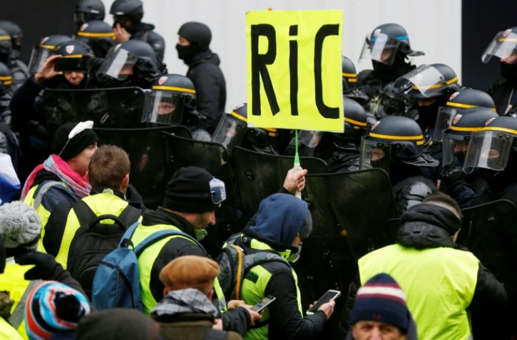 Une pancarte réclamant l'instauration d'un référendum d'initiative citoyenne (RIC) est brandie lors d'une manifestation de "gilets jaunes" à Paris, le 15 décembre 2018