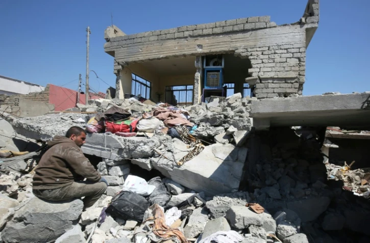 Un Irakien au milieu des décombres de sa maison détruite lors d'un raid visant le groupe EI le 26 mars 2017 dans le quartier al-Jadida à Mossoul  