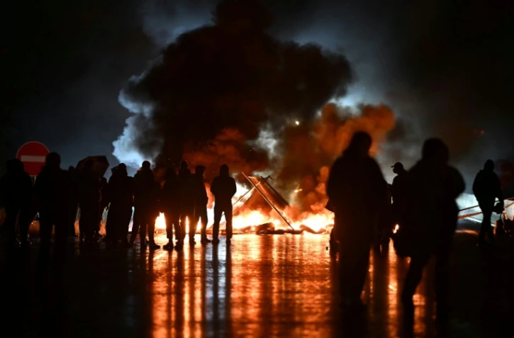 Des manifestants du mouvement "Bloquons tout" près d'objets en feu sur le viaduc de Calix, le 10 septembre 2025