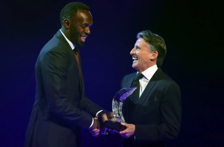 Usain Bolt reçoit son prix d'athlète de l'année des mains de Sebastian Coe, le patron de l'IAAF à Monaco, le 2 décembre 2016