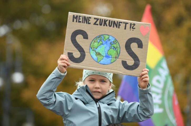 Une petite fille participant à la manifestation pour le climat à Berlin tient une pancart où est inscrit "Mon avenir ?! SOS", le 22 octobre 2021