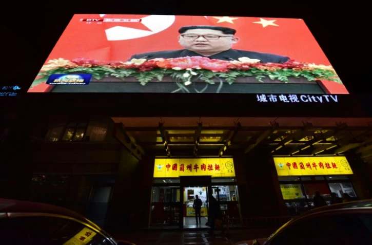 Le dirigeant nord-coréen Kim Jong Un apparaît sur les écrans lors de sa rencontre avec le présient chinois Xi Jinping à Pékin le 28 mars 2018