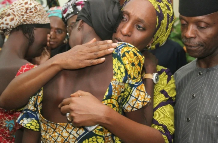 Le vice-président du Nigeria Yemi Osinbajo (d) regarde sa femme Dolapo (c) consoler l'une des 21 jeunes filles de Chibok libérées à Abuja le 13 octobre 2016