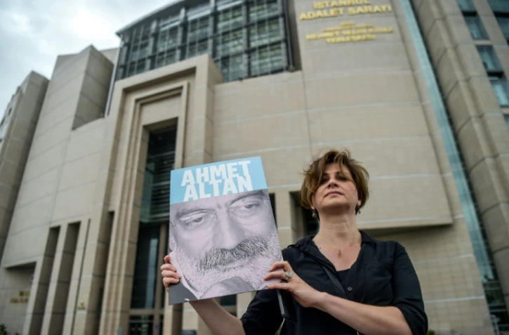 Une journaliste pose avec un portrait du journaliste Ahmet Altan, à Istanbul, le 19 juin 2017