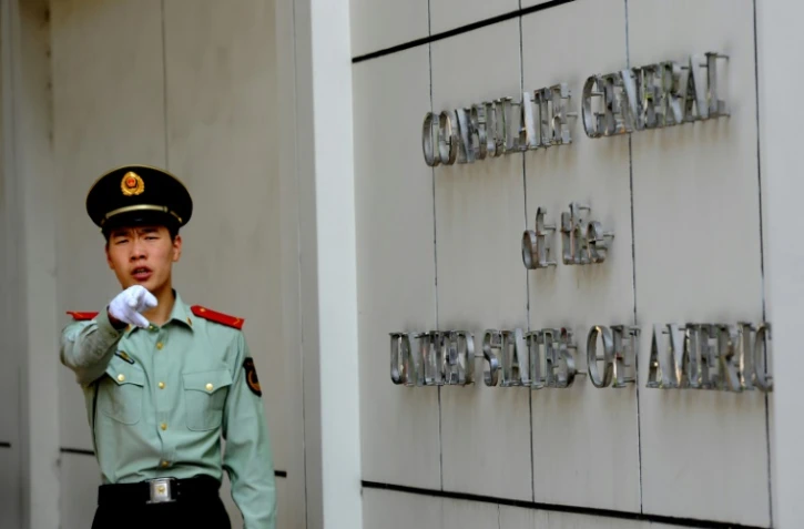 Un policier chinois pointant du doigt les journalistes devant le consulat américain à Chengdu, sud-ouest de la Chine, le 18 septembre 2012
