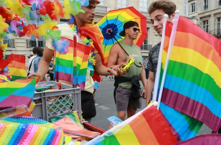 Un homme vend des drapeaux couleur arc-en-ciel lors de la gay pride Ă Paris, le 24 juin 2017