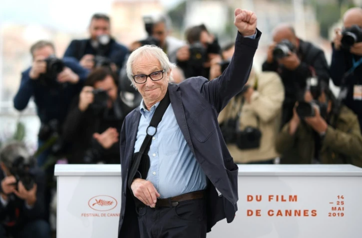 Le réalisateur britannique Ken Loach lève le poing devant les photographes pour le film "Sorry We Missed You" lors de la 72e édition du Festival de Cannes, le 17 mai 2019