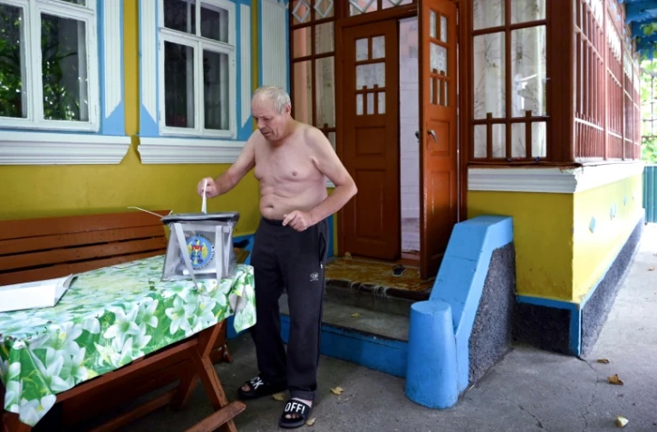 Un électeur vote devant sa maison dans le village de Gura Bicului, à 70 kilomètres de la capitale moldave Chisinau, le 11 juillet 2021
