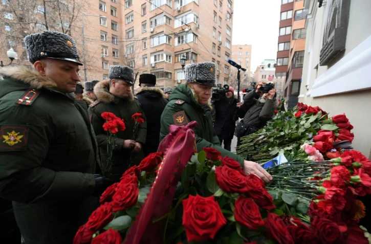 Des soldats russes déposent des roses rouges devant l'immeuble de l'"Ensemble Alexandrov" le 26 décembre 2016 à Moscou