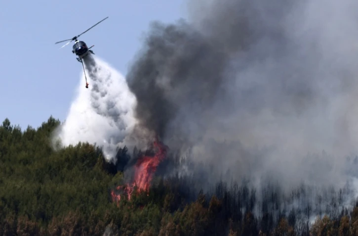 Un hélicoptère Airbus H125 largue de l'eau sur un incendie de forêt à Taradeau, le 20 juillet 2026 dans le Var