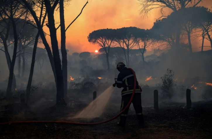 Un pompier français utilise une lance d'incendie lors d'un feu de forêt dans le département du Var, dans le sud de la France, le 17 août 2021