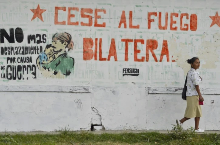 Une femme passe devant une inscription "Cessez-le-feu bilatéral", le 28 août 2016 à El Palo en Colombie