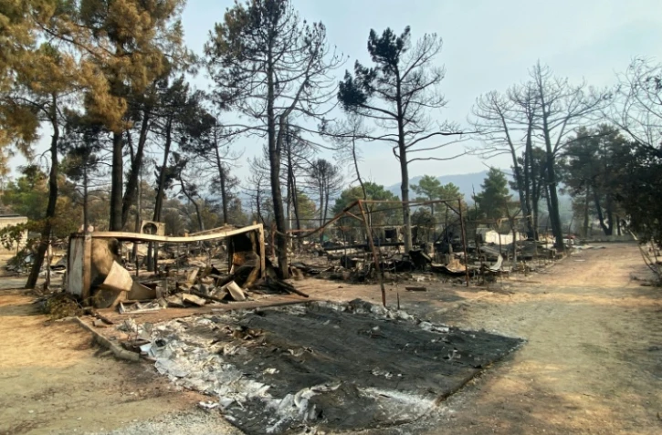 Restes calcinés de caravanes et de tentes dans un camping du Pantano de Burguillo, à El Barraco, à 100 kilomètres à l'ouest de Madrid, le 27 juillet 2026