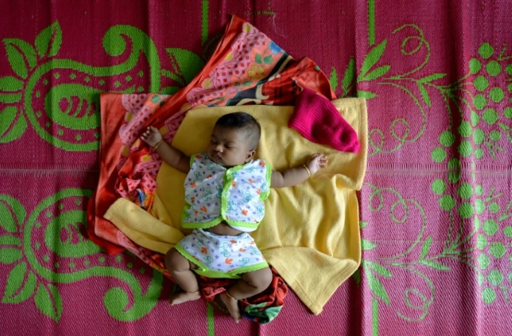 Un bébé dort sur une natte dans un camp d'Aluva, près de Cochin, au Kerala le 20 août 2018