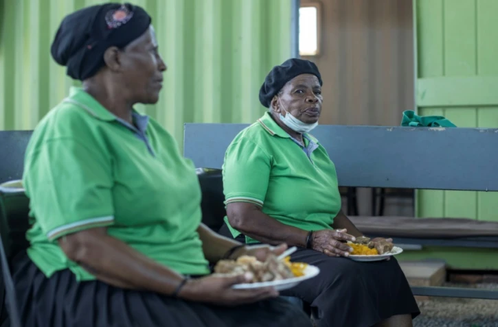 Des résidentes d'une maison de retraite mangent un repas préparés à partir d'invendus, le 17 février 2021 à Johannesburg, en Afrique du Sud
