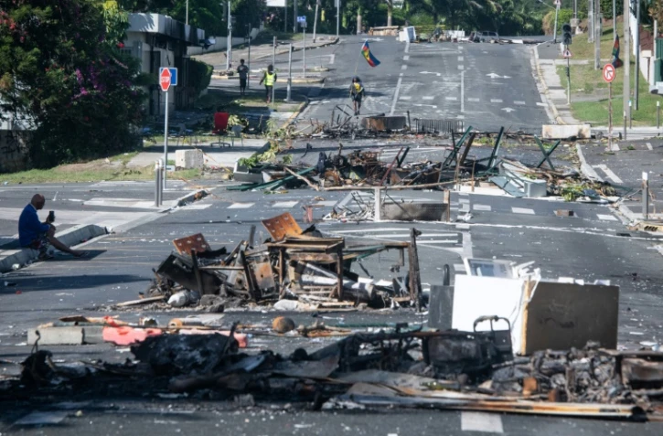 Une rue bloquée par des objets incendiés et des débris, dans le quartier Magenta à Nouméa en Nouvelle-Calédonie, le 18 mai 2024