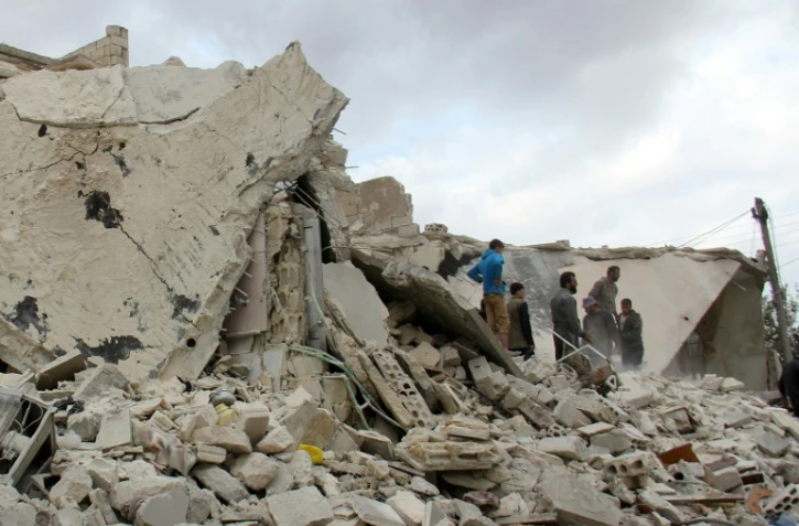 Des habitants recherchent des victimes dans les décombres d'immeubles après une frappe aérienne des forces russes et syriennes, le 16 novembre 2016 à Idleb