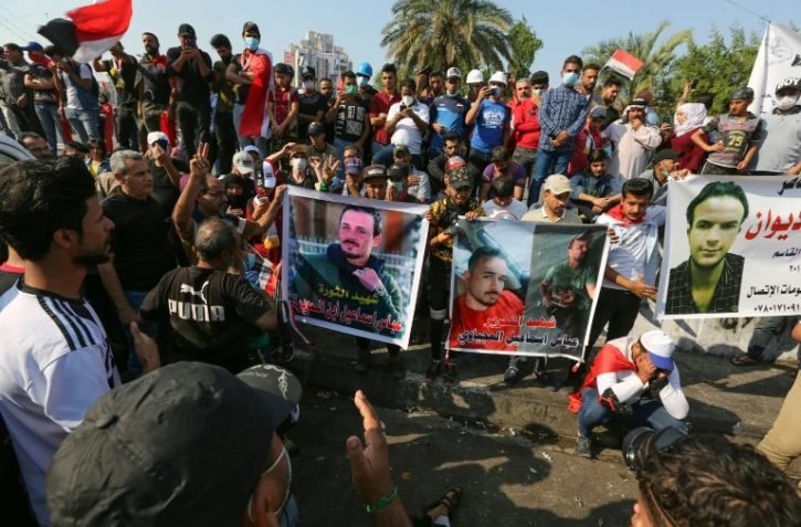 Des manifestants irakiens brandissent les portraits de leurs camarades tués, sur la place Tahrir à Bagdad, le 2 novembre 2019