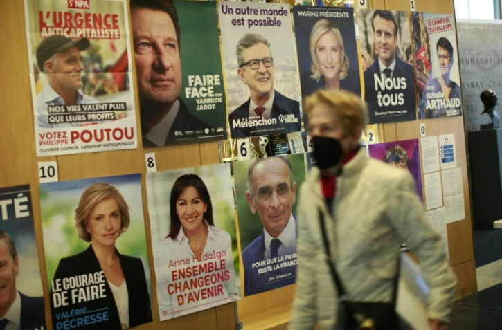 Une femme passe devant les affiches électorales des candidats à la présidentielle, près du lycée français à New York où des électeurs commençaient à voter, le 9 avril 2022