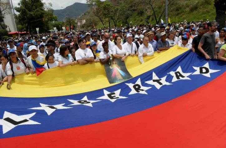 Des manifestants anti-Maduro marchent vers le siège de l'Eglise catholique à Caracas, le 22 avril 2017