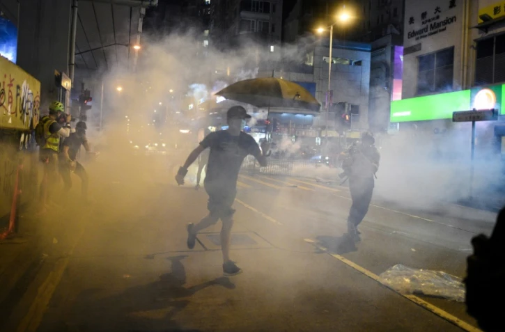 La police de Hong Kong a recours à des tirs de gaz lacrymogène contre des manifestants le 7 octobre dans le district de Mongkok